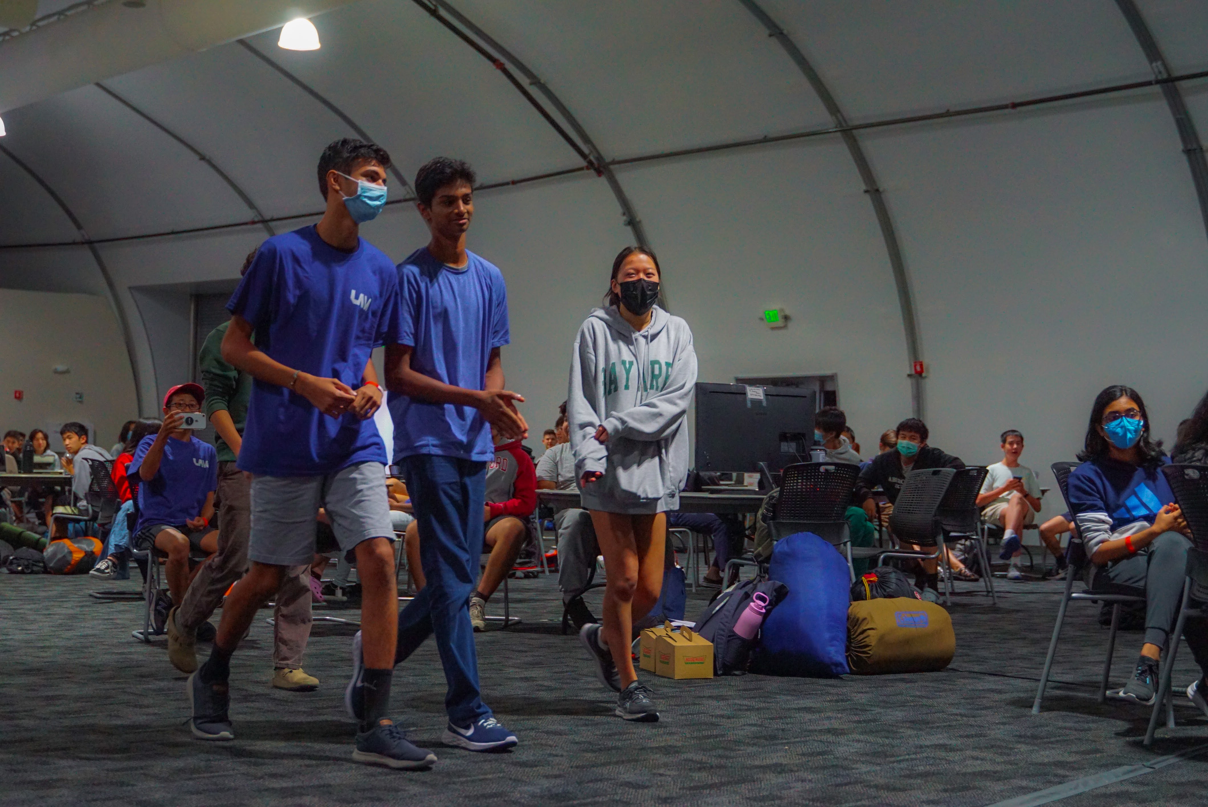 A group of two boys and one girl walking to collect their award at Los Altos Hacks VI.